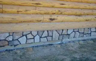 stone masonry accent on log home